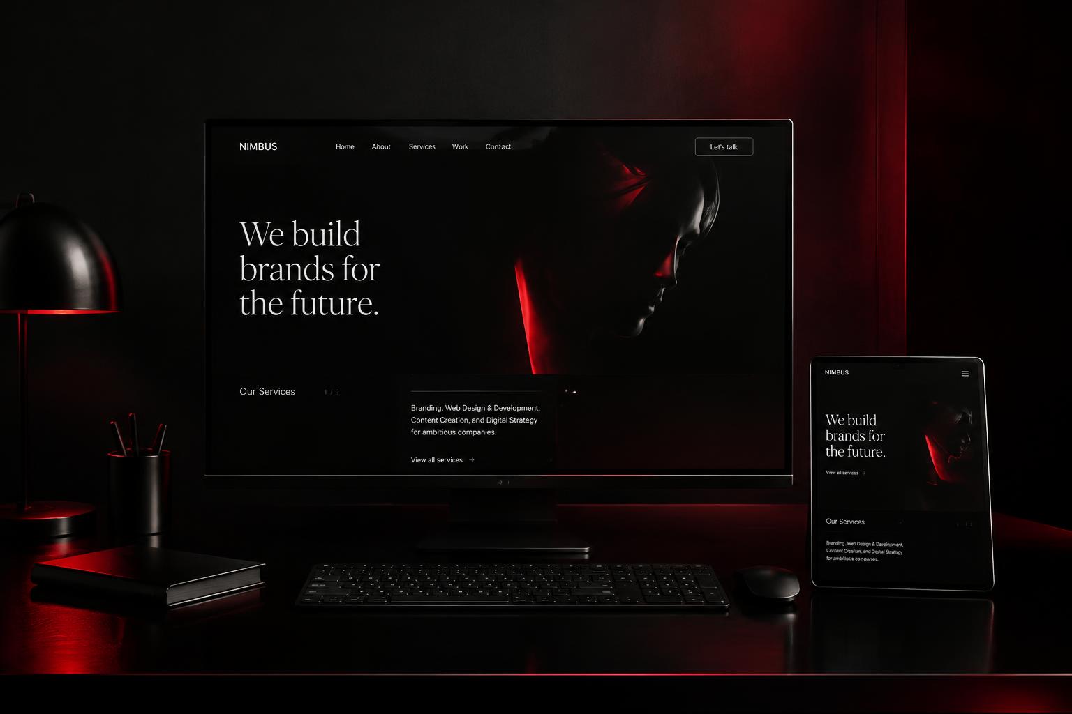 Dark studio desk with a website shown on a monitor and tablet